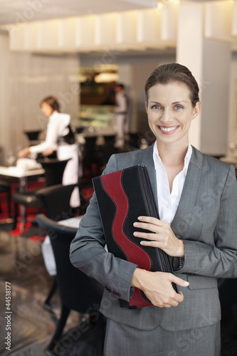 Photo: Portrait of smiling hostess in restaurant Portrait of smiling hostess in restaurant