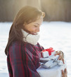 Smiling woman carrying Christmas gifts