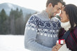 Smiling couple face to face in snowy field