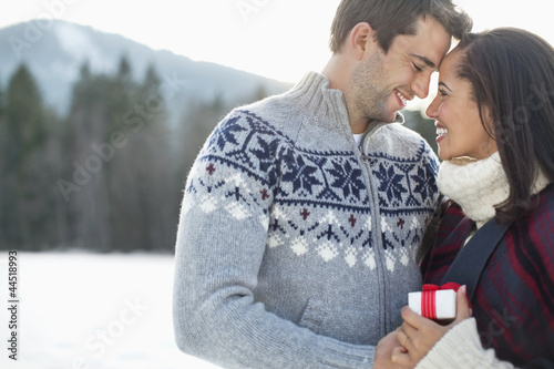 Photo: Smiling couple face to face in snowy field Smiling couple face to face in snowy field