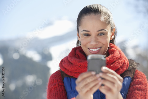 Photo: Smiling woman checking cell phone Smiling woman checking cell phone