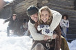 Portrait of smiling couple hugging with friends in background