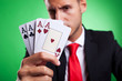 young business man showing a four of a kind hand of aces