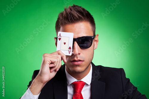 Photo: business man covers one eye with an ace of hearts business man covers one eye with an ace of hearts