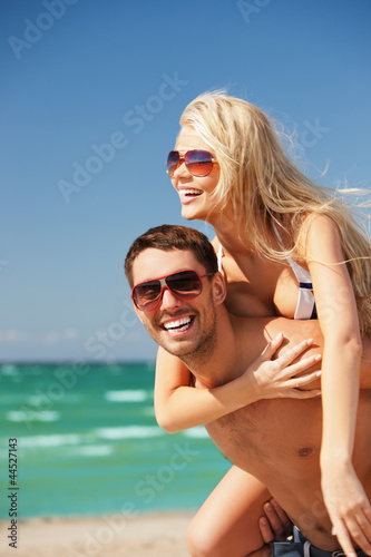 Photo: happy couple in sunglasses on the beach happy couple in sunglasses on the beach