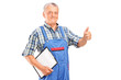 Mature mechanic holding a clipboard and giving a thumb up