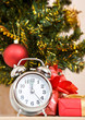 Photo: Soon new year! Hours and a gift stand under a fir-tree Soon new year! Hours and a gift stand under a fir-tree