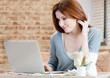 Woman is working on the laptop at the internet cafe