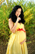 Pregnant woman caressing her belly, with her finger on lips