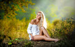 beautiful  blonde girl in white dress sitting in grass