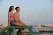 happy couple with small car on vacation