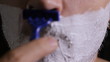 man shaves disposable razor close up