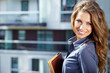 Businesswoman standing outside a modern house