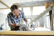 Foto: Man using electric saw inside house under construction Man using electric saw inside house under construction
