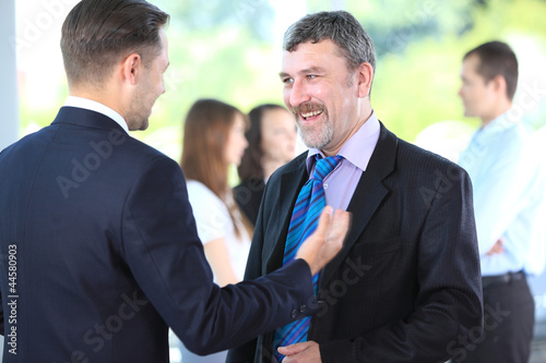 Photo: Business people discussing. Everyday setting Business people discussing. Everyday setting