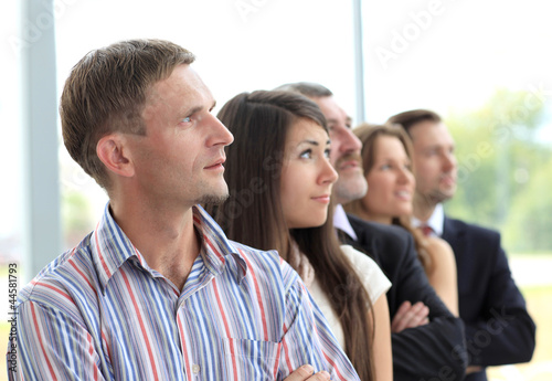 Photo: business team standing in a row at office and looking upwards business team standing in a row at office and looking upwards
