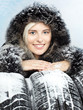 Beautiful woman presenting winter tyres for your safety
