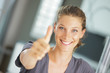 Close-up of a happy young woman showing thumbs up sign