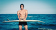 Strong young surf man portrait at the beach with a surfboard.