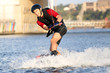 Wakeboarder surfing across a river