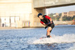 Wakeboarder surfing across a river