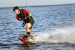 Wakeboarder surfing across a river