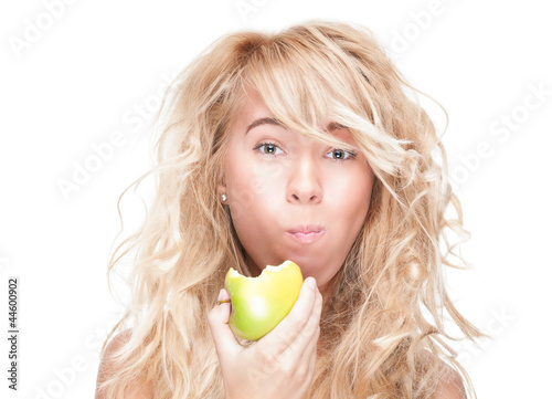 Photo: Young girl eating green apple on white background. Young girl eating green apple on white background.