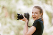 smiling young woman photographs on camera