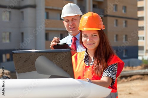 Photo: two builders works on the building site two builders works on the building site