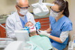Dentist with nurse doing procedure on patient