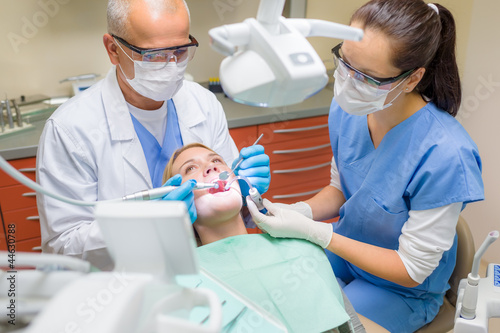 Foto: Dentist with nurse doing procedure on patient Dentist with nurse doing procedure on patient