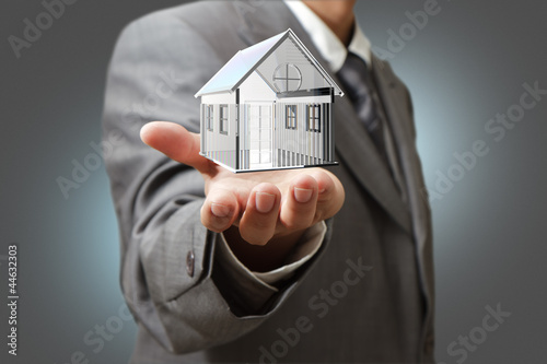 Photo: Business man present diamond house model Business man present diamond house model