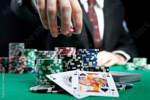 Photo: blackjack in a casino, a man makes a bet, and puts a chip blackjack in a casino, a man makes a bet, and puts a chip