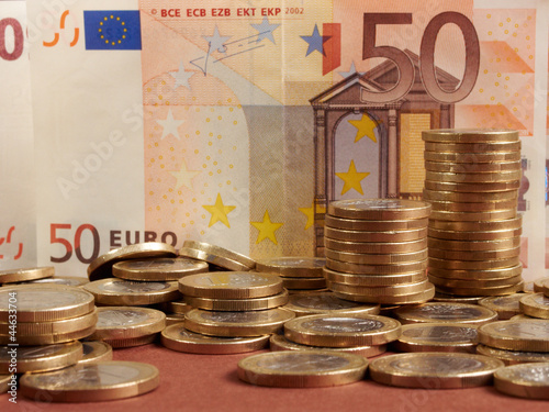 Photo: Euro coins on banknote money background Euro coins on banknote money background