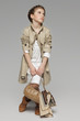Lovely girl wearing beige trench coat looking to side