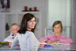 Mother helping her children with their homework