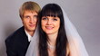 happy groom and beautiful bride look into camera in studio