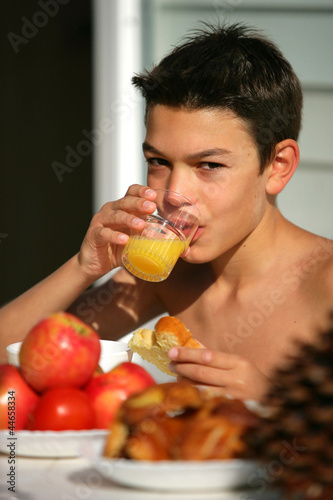 Photo: Young boy drinking orange juice in the garden Young boy drinking orange juice in the garden
