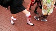 Girls zombies walk by pavement and carry bloody baby
