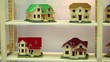 Many models of houses on wooden shelves