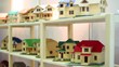 Lot of models of houses on wooden shelves