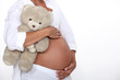 Pregnant woman holding teddy bear