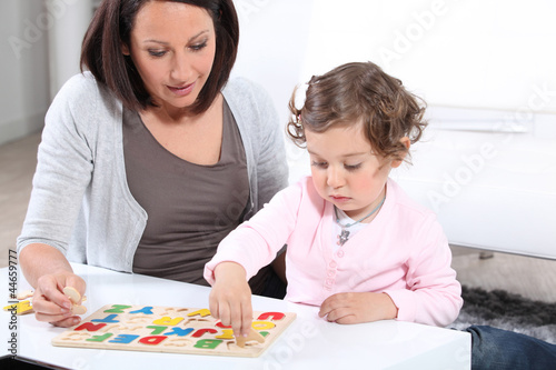 Photo: Mother and daughter completing a letter puzzle Mother and daughter completing a letter puzzle
