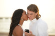Photo: Man secretly texting while being kissed Man secretly texting while being kissed
