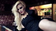 Gorgeous blonde woman lying on bar counter with wine