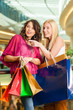 Two women shopping with bags in mall
