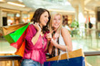 Two women shopping with bags in mall