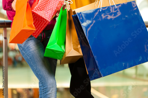 Photo: Two women shopping with bags in mall Two women shopping with bags in mall