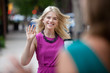Foto: Woman Waving Hello on Street Woman Waving Hello on Street
