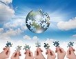 Business concept with a hand building puzzle globe